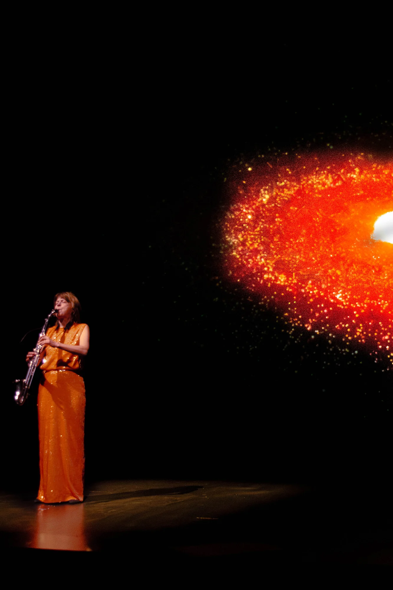 The basset horn player beside the galaxy projection